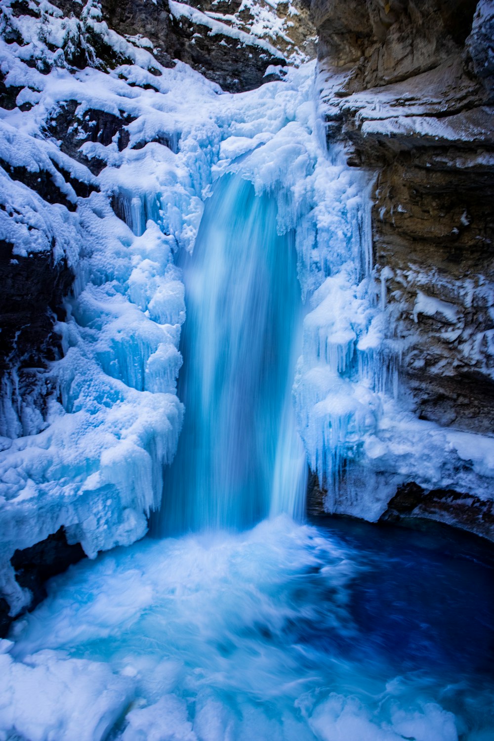 a frozen waterfall in the middle of a mountain