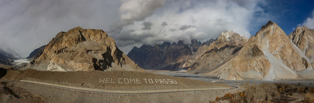 a scenic view of a mountain range with a welcome sign