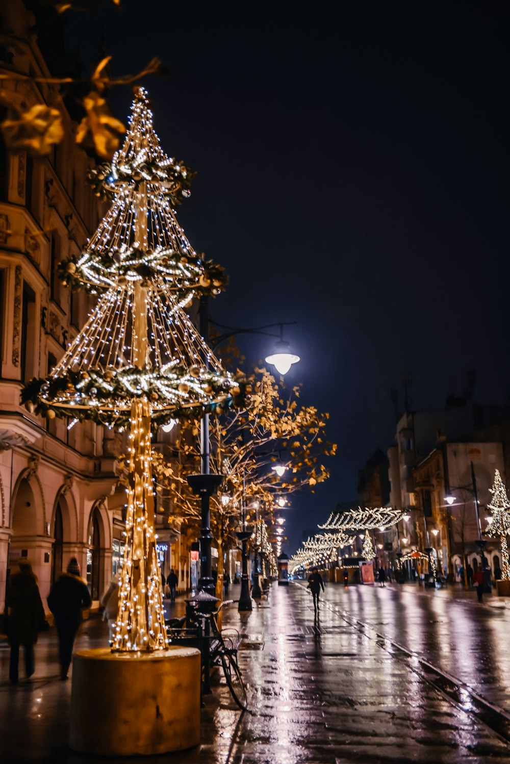 a lighted christmas tree on a city street