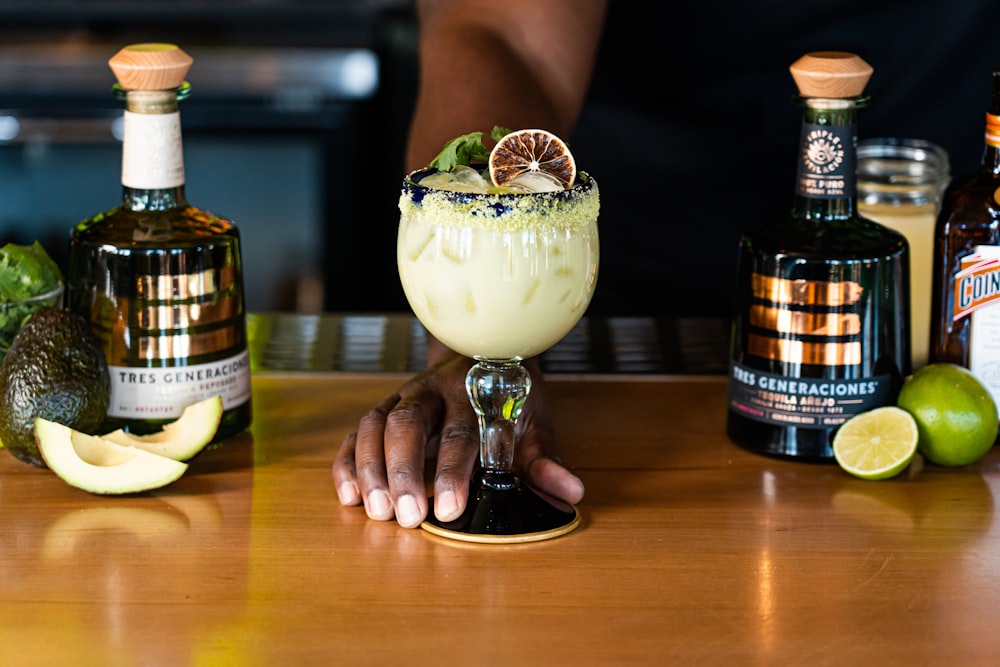 a person sitting at a bar with a margarita