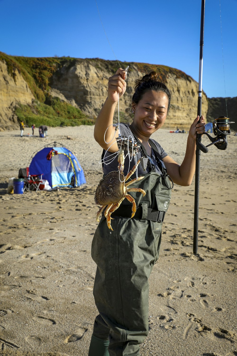 a woman holding a fish on a beach