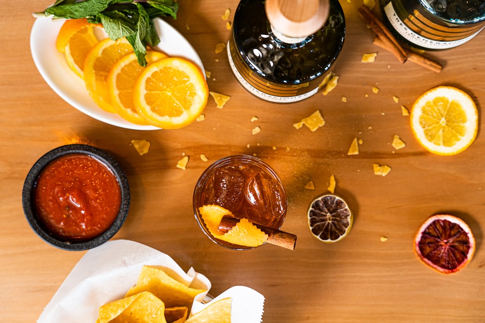 a wooden table topped with plates of food and drinks