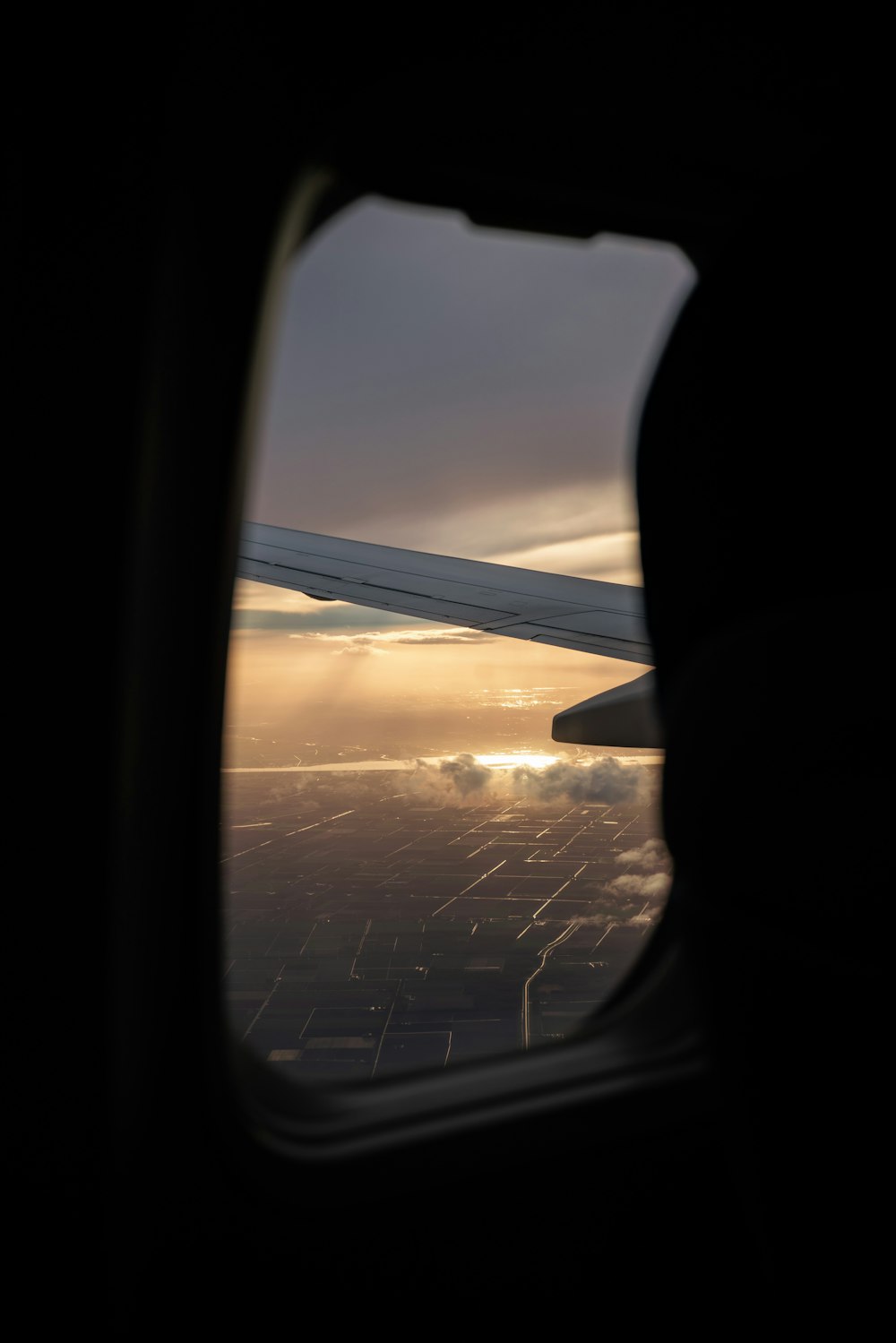 a view of the wing of an airplane as the sun sets
