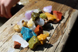 Close-up of colorful natural gemstones arranged on a wooden surface, highlighting their textures and colors.