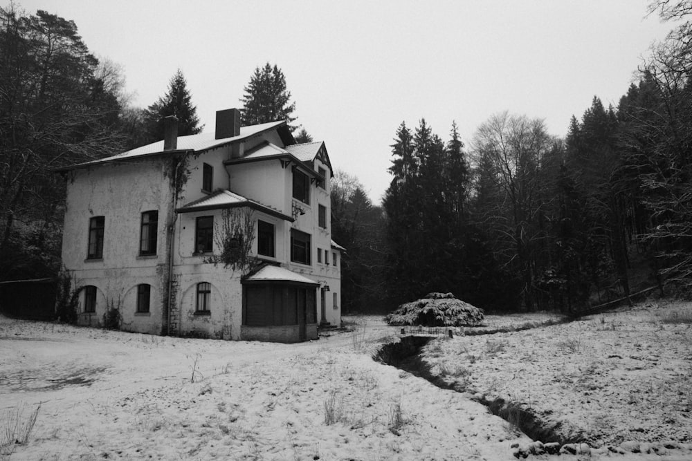 an old house in the middle of a snowy field