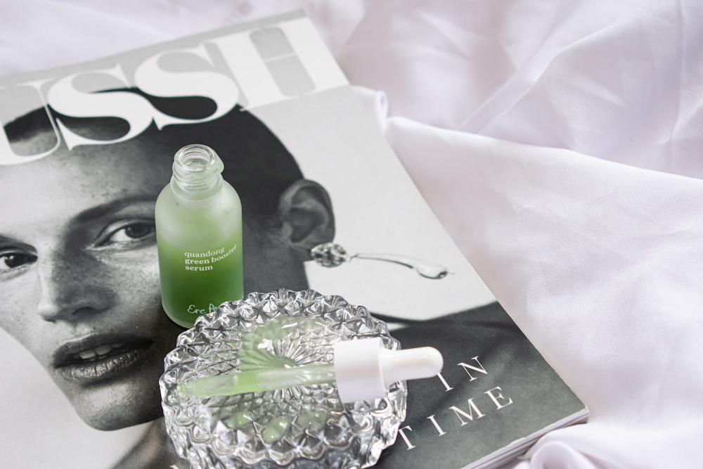 a magazine with a bottle of green liquid next to it