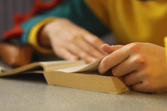 a person sitting at a table with a book