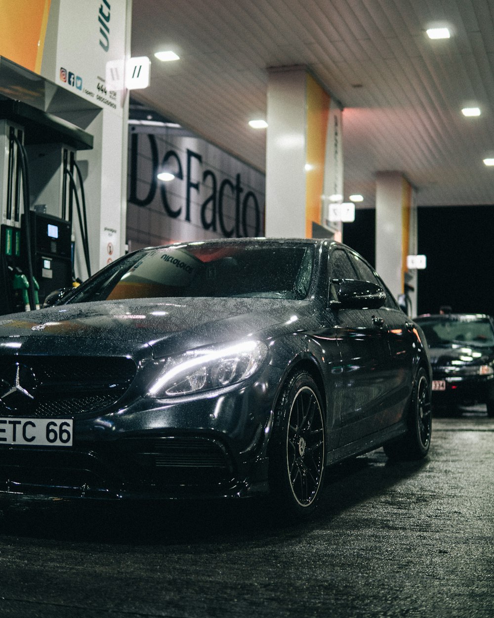 a black car parked in front of a gas station