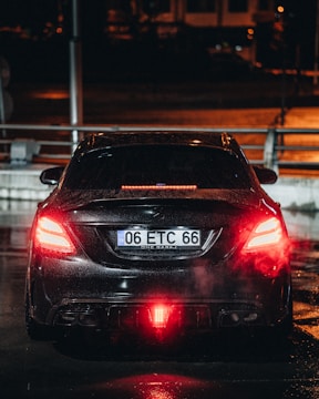 a car driving down a wet street at night