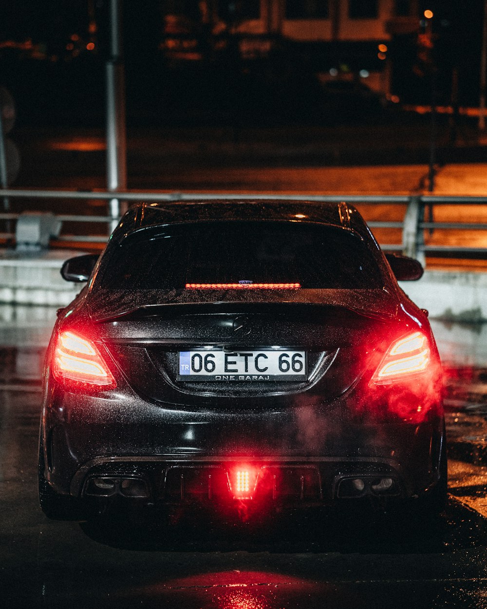 a car driving down a wet street at night