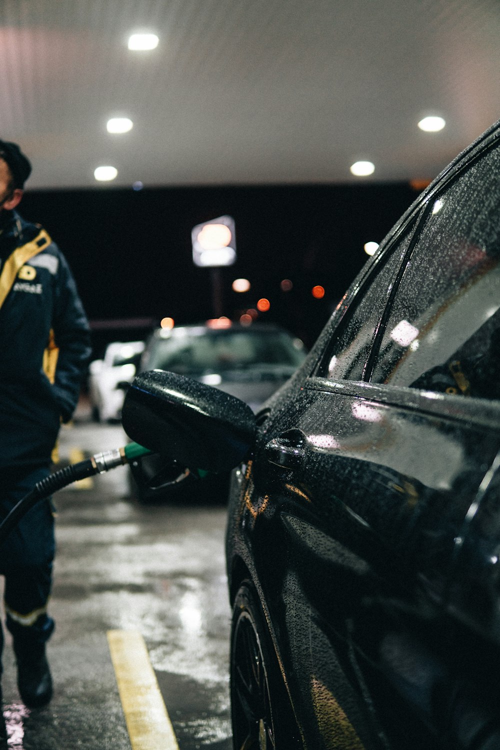 a man in a gas station filling his car with gas