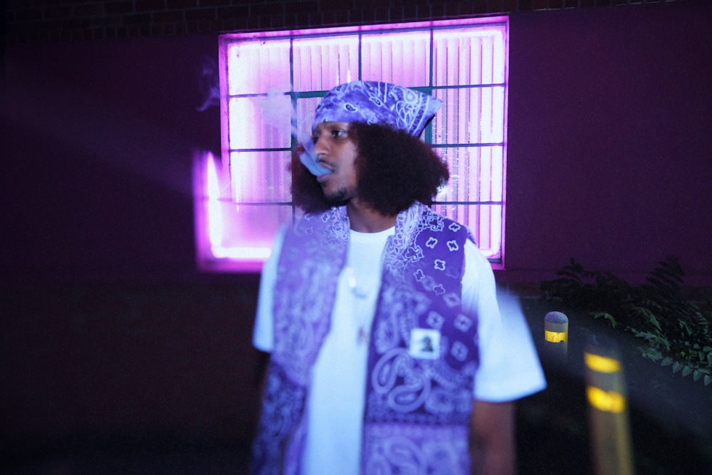 um homem de pé na frente de uma luz púrpura