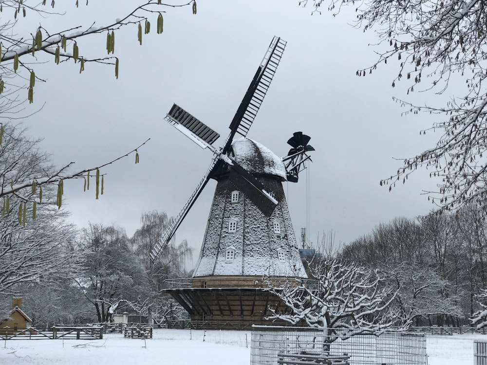 a windmill in the middle of a snowy field