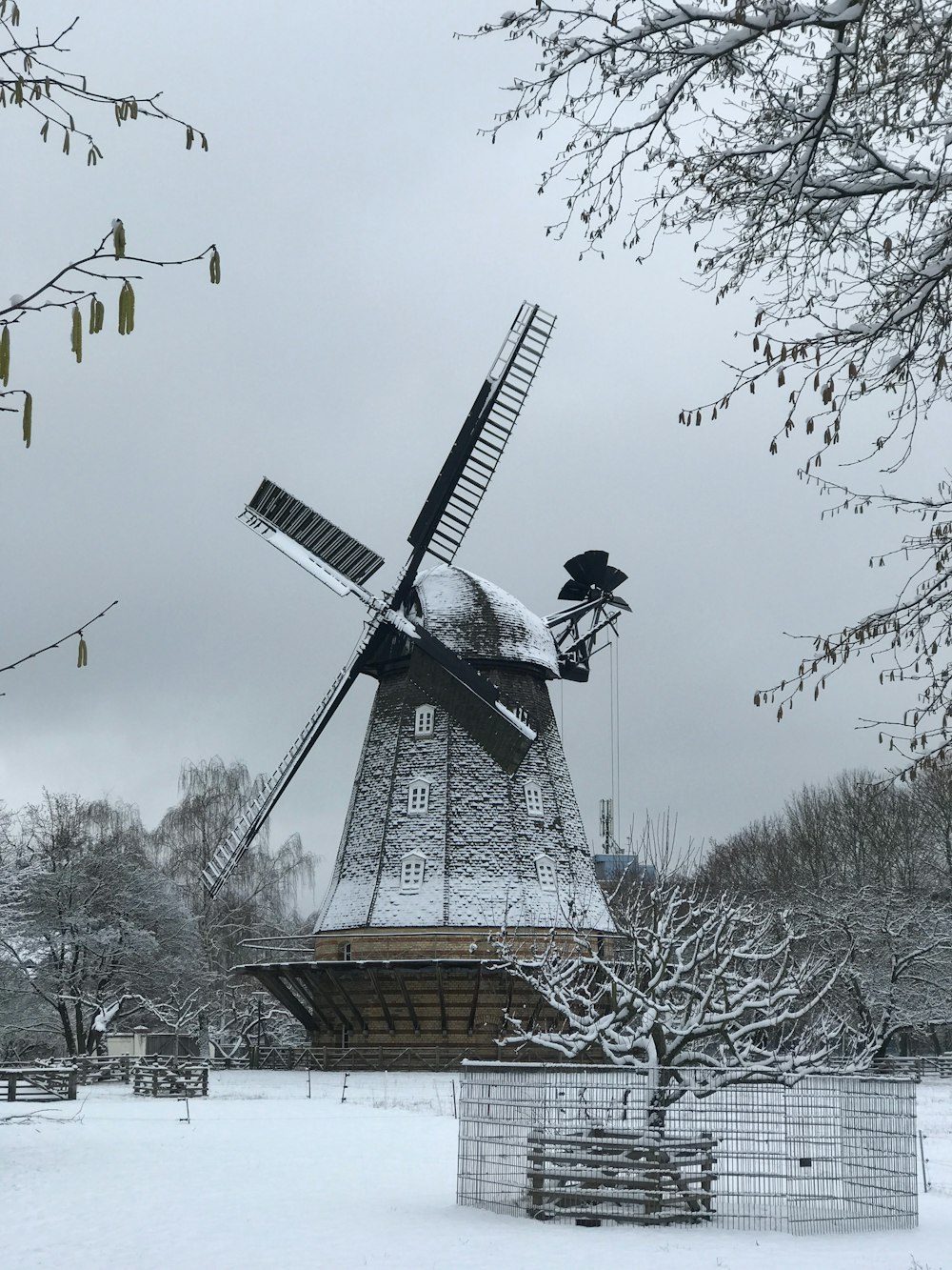 a windmill in the middle of a snowy field
