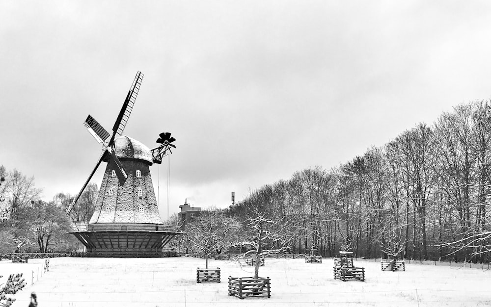 a black and white photo of a windmill in the snow