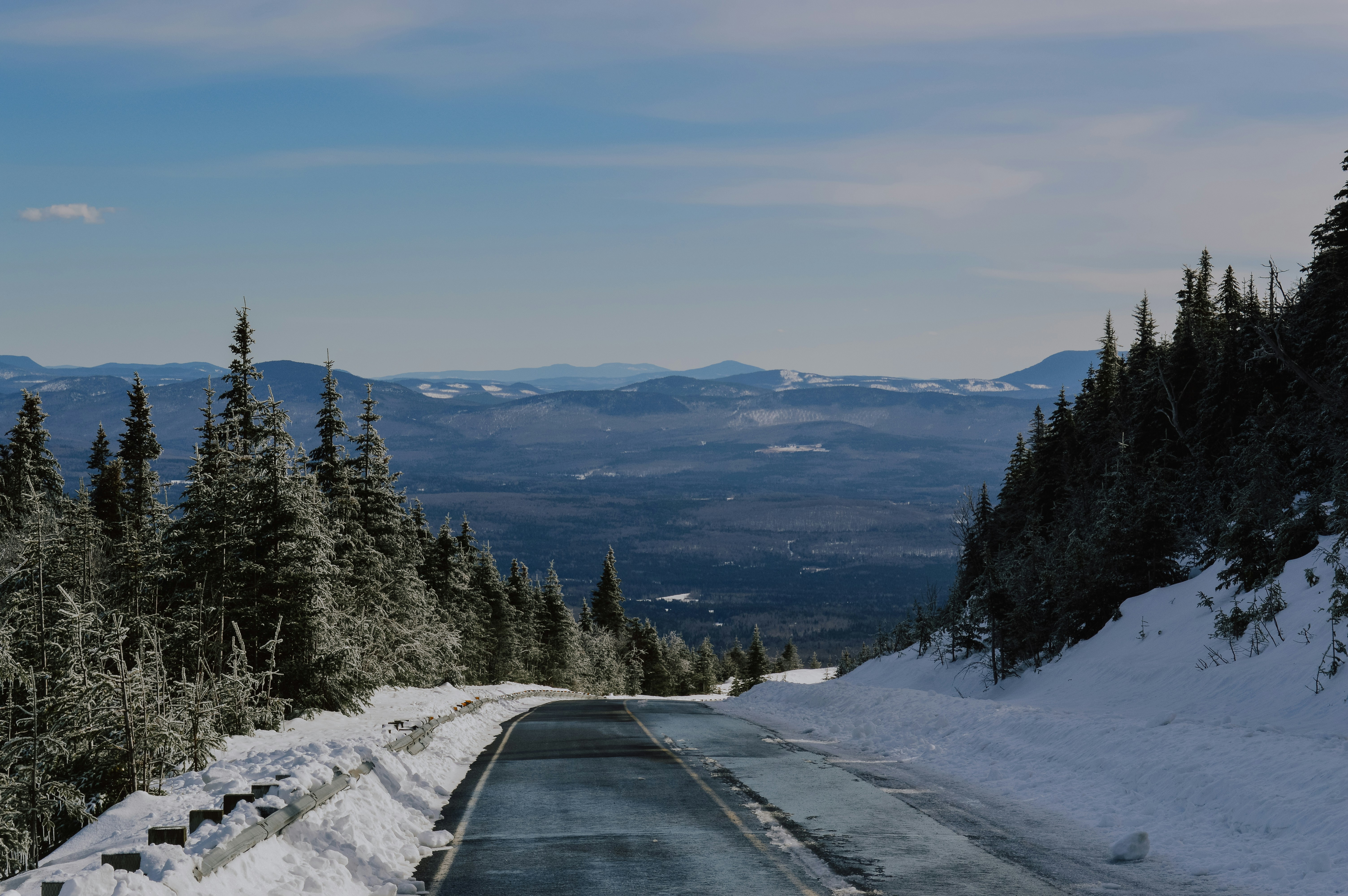 a road with snow on the side and trees on the side