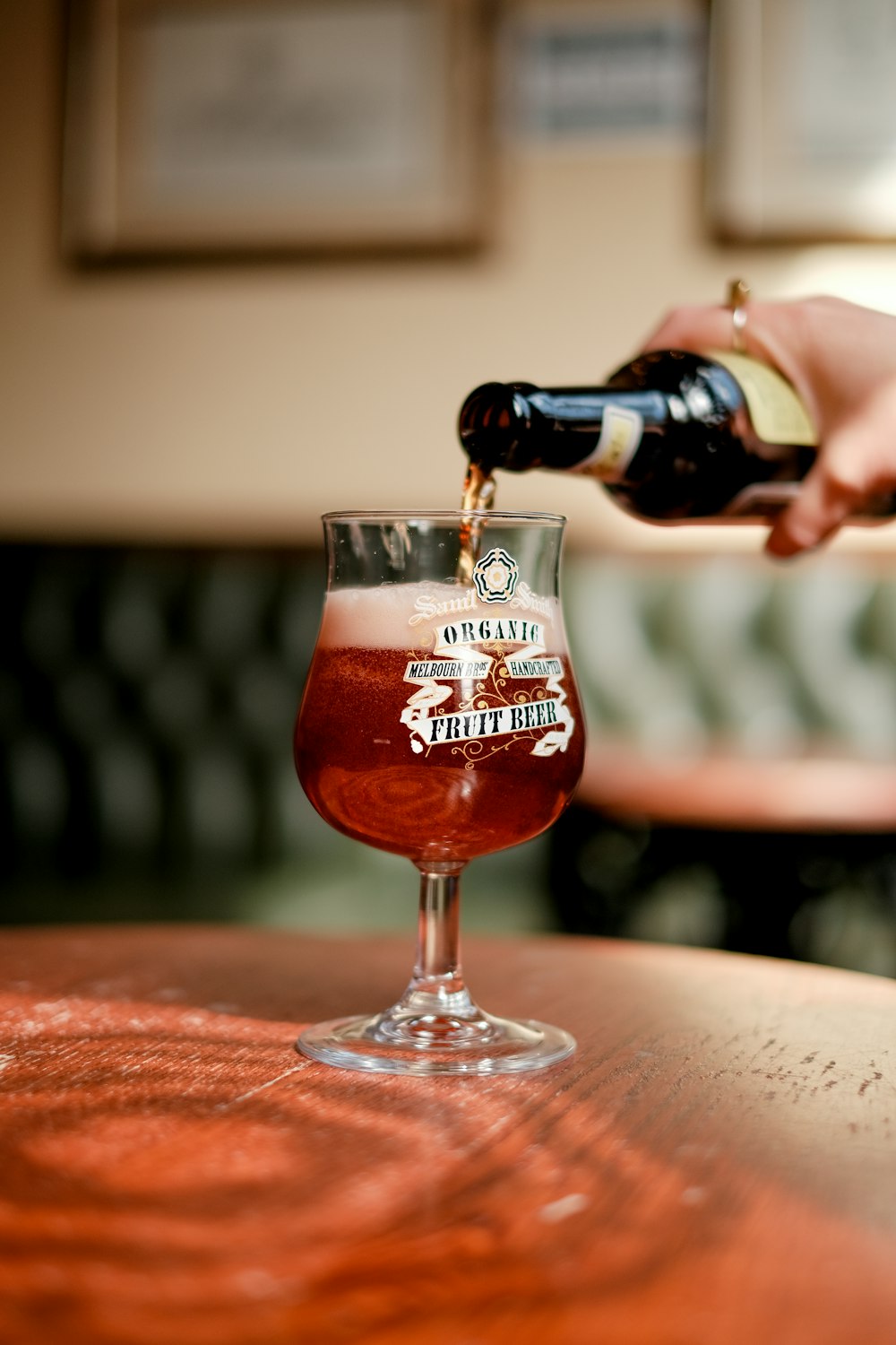 a person pouring a beverage into a wine glass