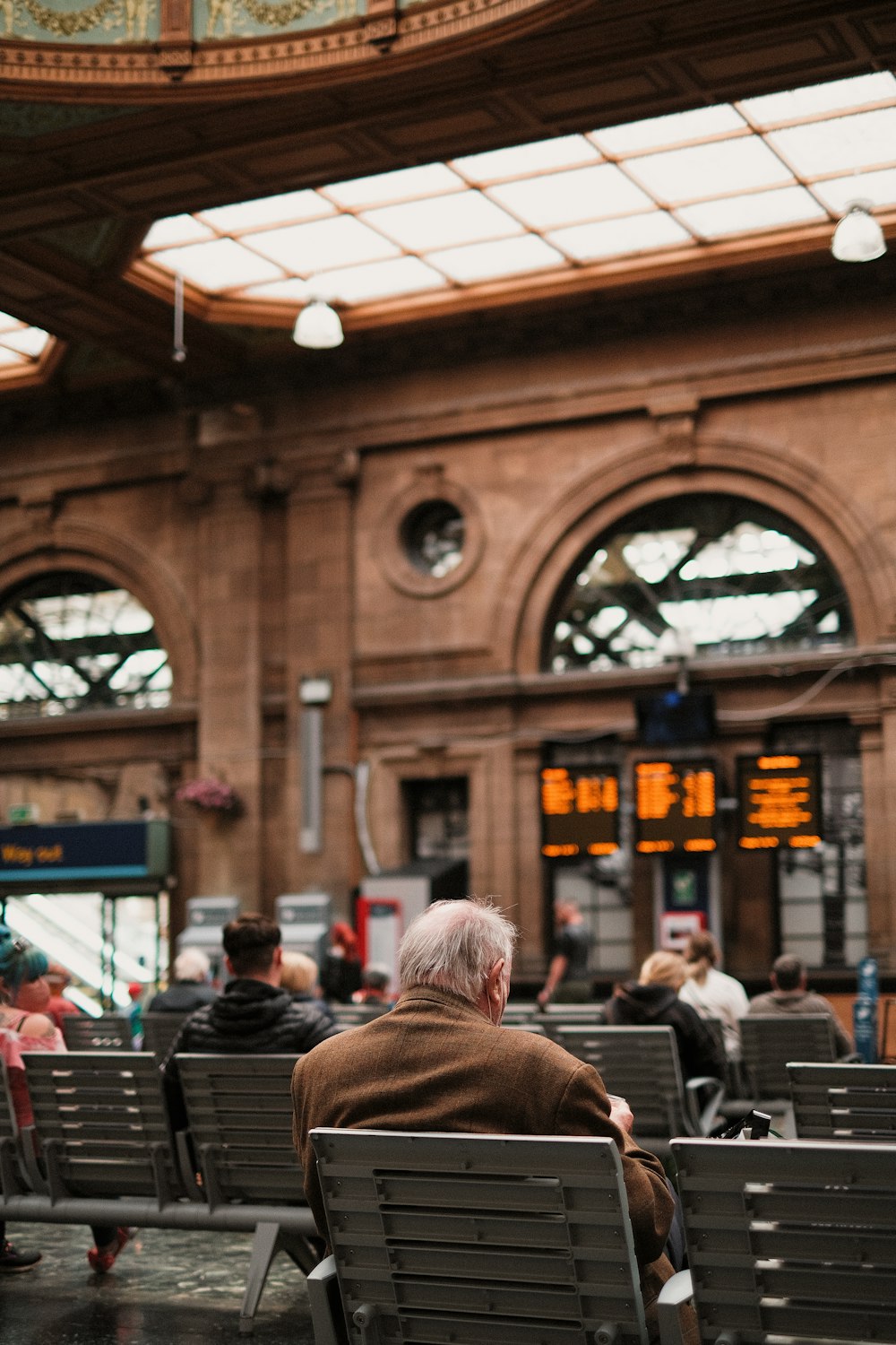 a man sitting on a bench in a train station