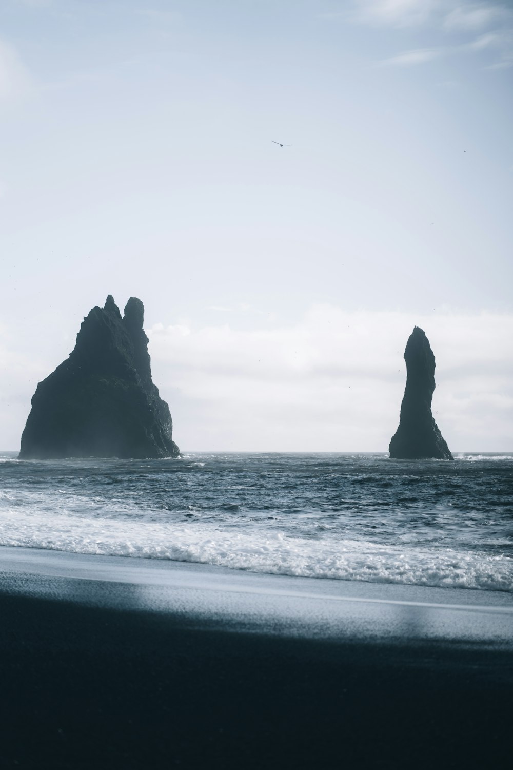 a couple of large rocks sticking out of the ocean