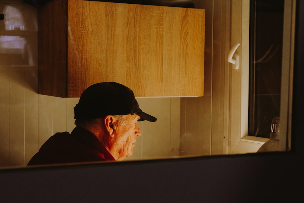 a man wearing a hat looking in a mirror