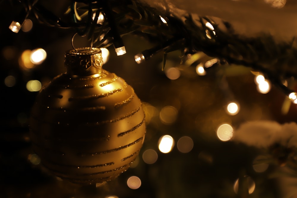 a gold ornament hanging from a christmas tree