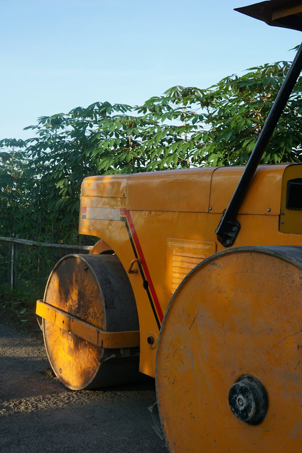 a close up of a yellow machine near a fence
