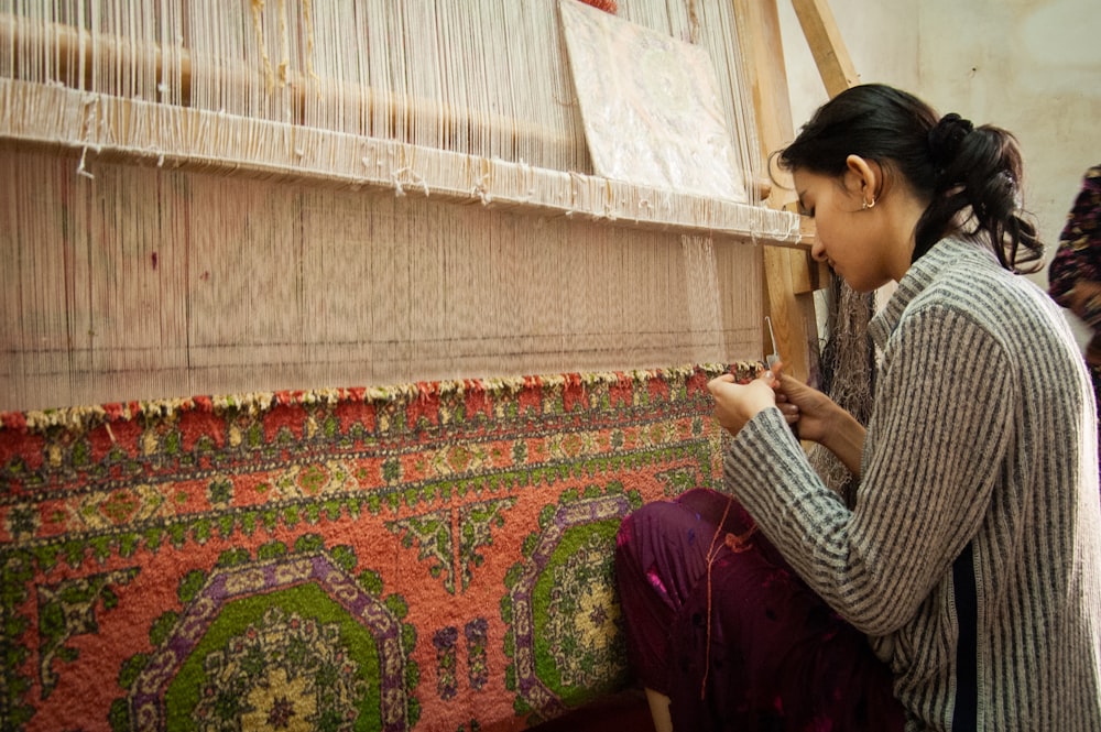 uma mulher está trabalhando em uma máquina de tecelagem