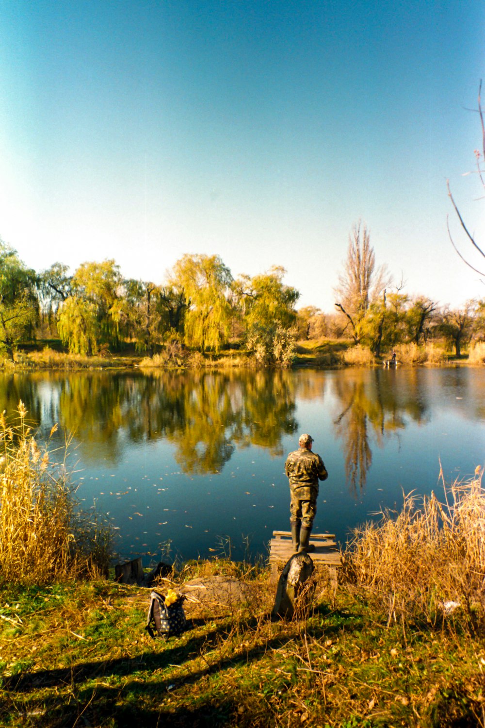 a man standing next to a body of water