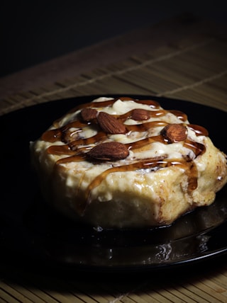 a black plate topped with a dessert covered in caramel