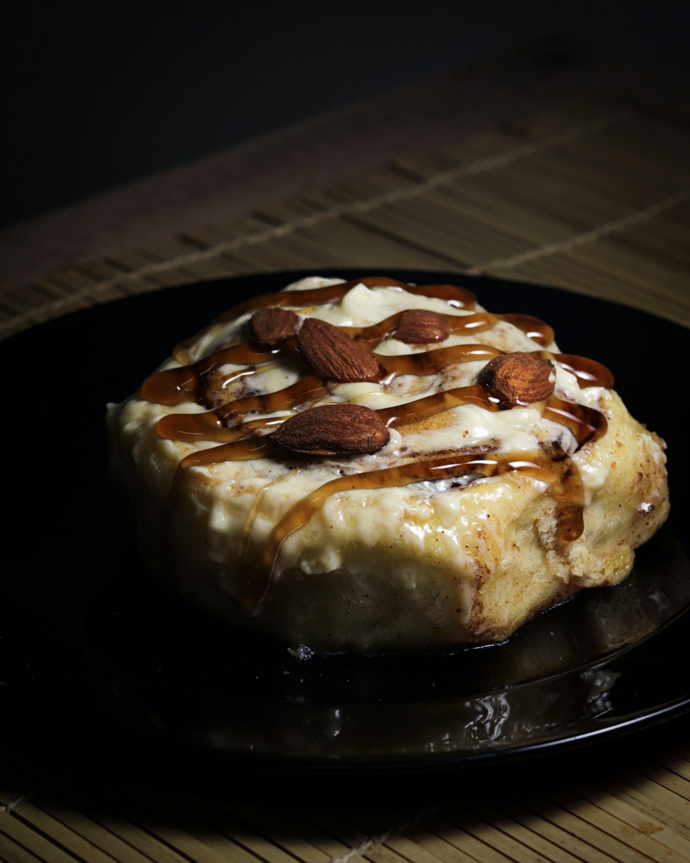 a black plate topped with a dessert covered in caramel