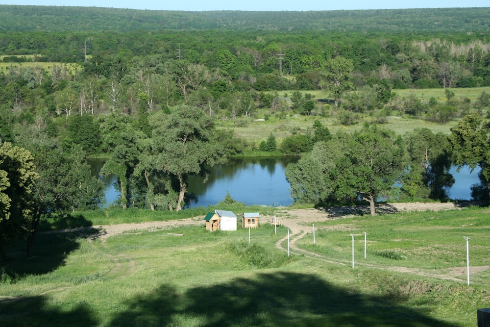 a view of a lake and a small cabin in the middle of a field
