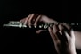 a person playing a flute in the dark