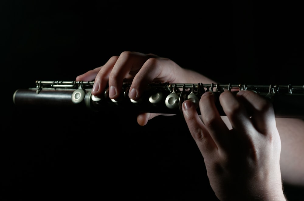 uma pessoa tocando uma flauta no escuro