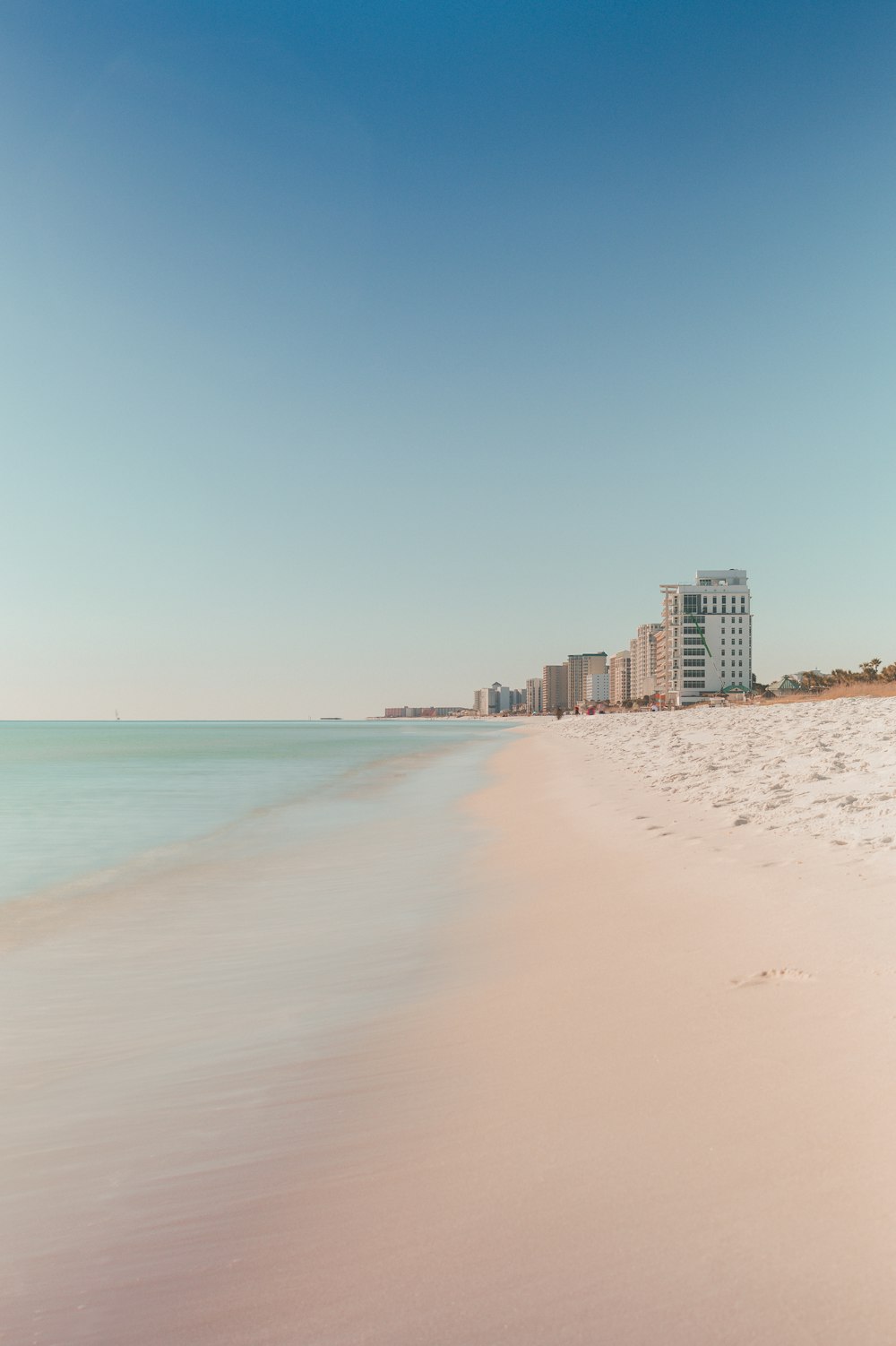 a sandy beach with buildings in the background