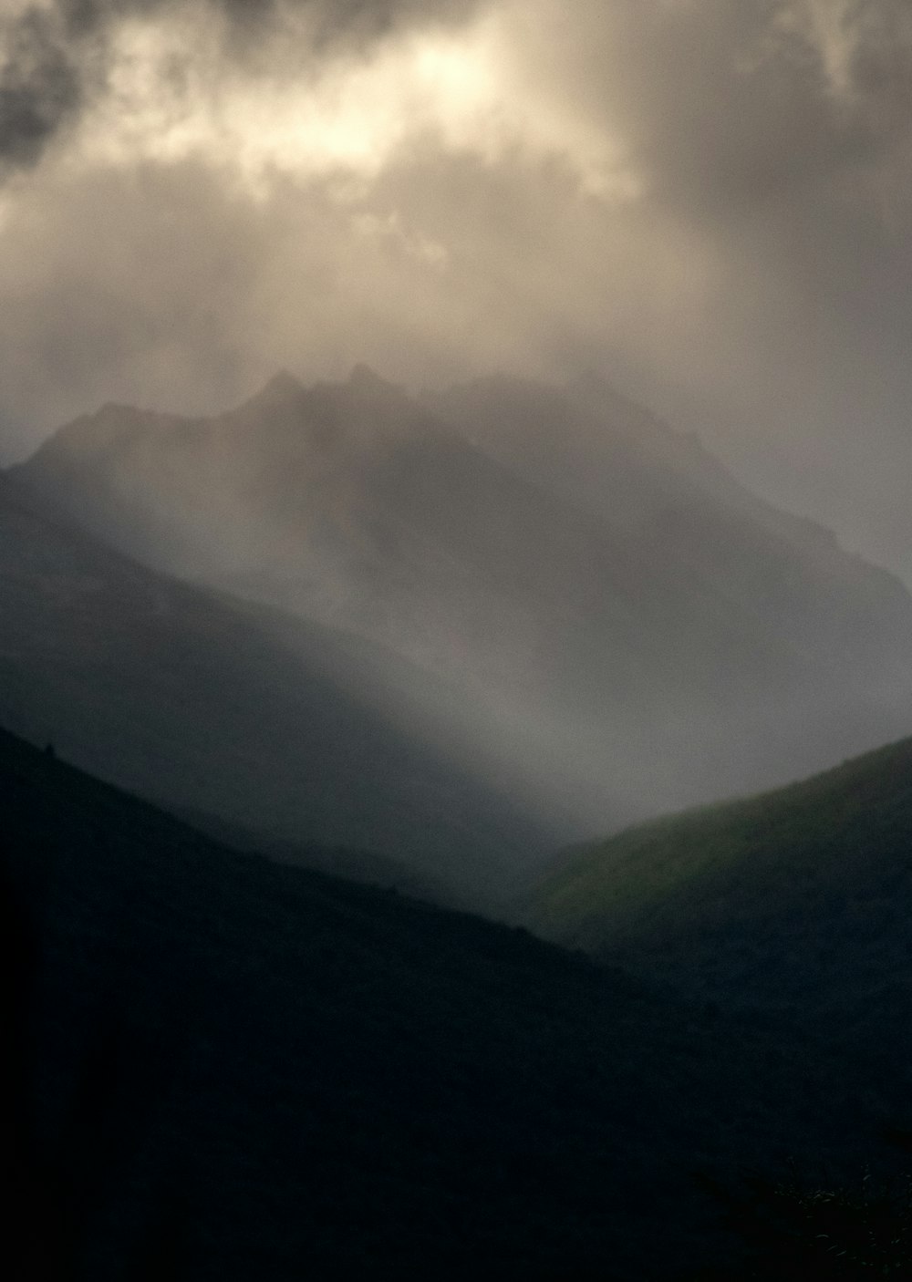 the sun is shining through the clouds in the mountains