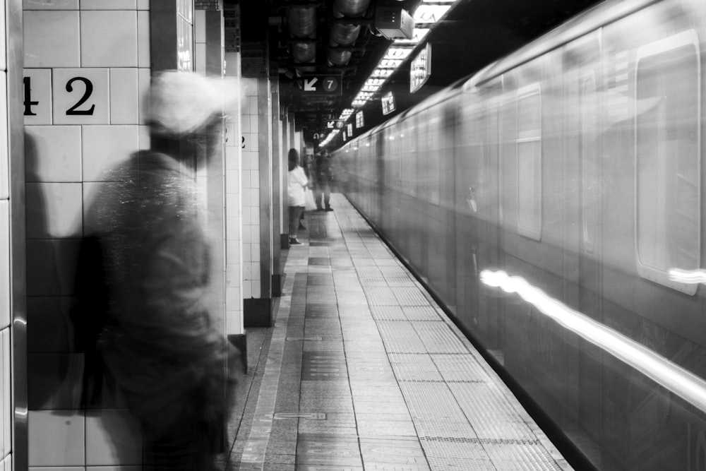 a black and white photo of a subway platform