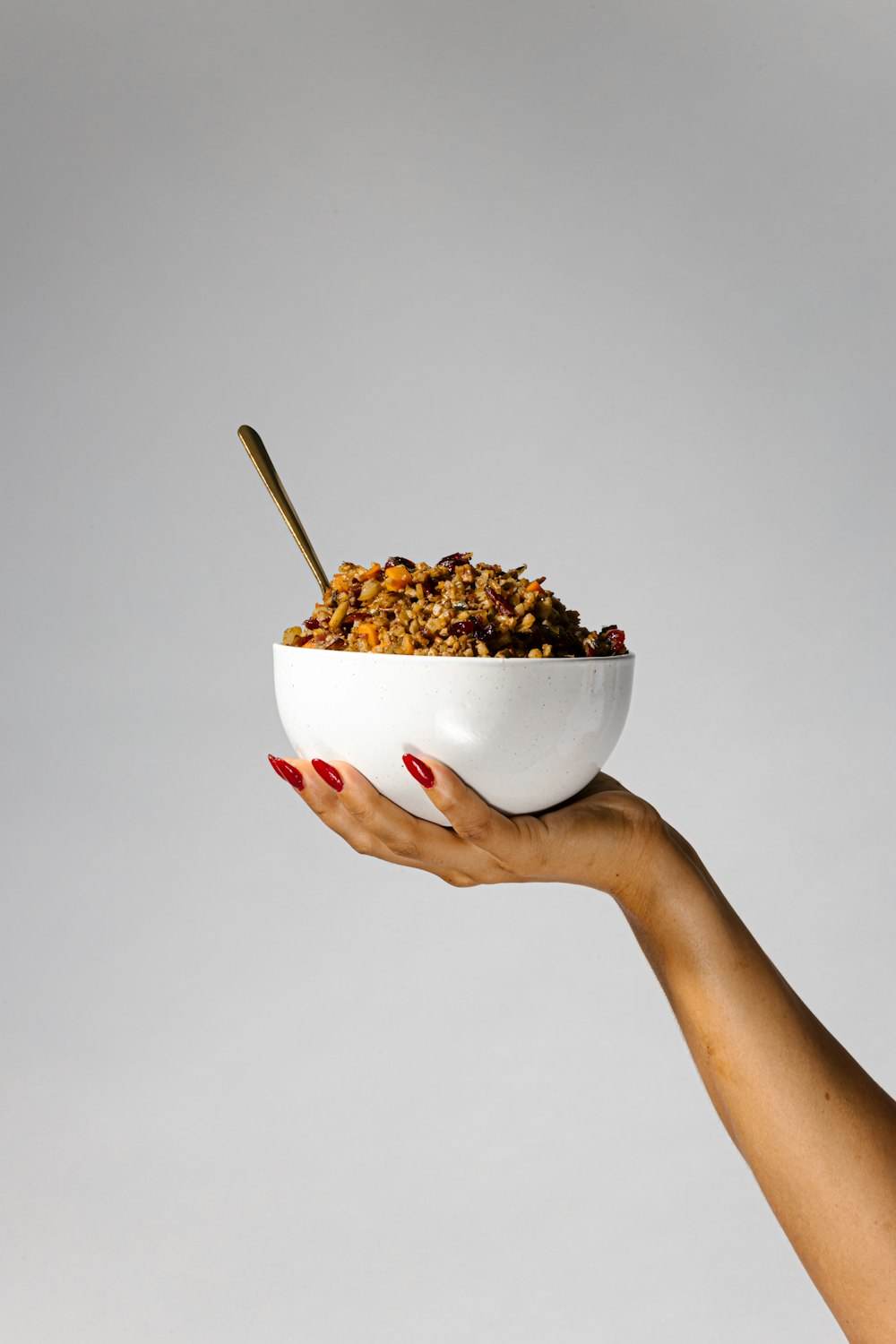 a woman's hand holding a bowl of cereal