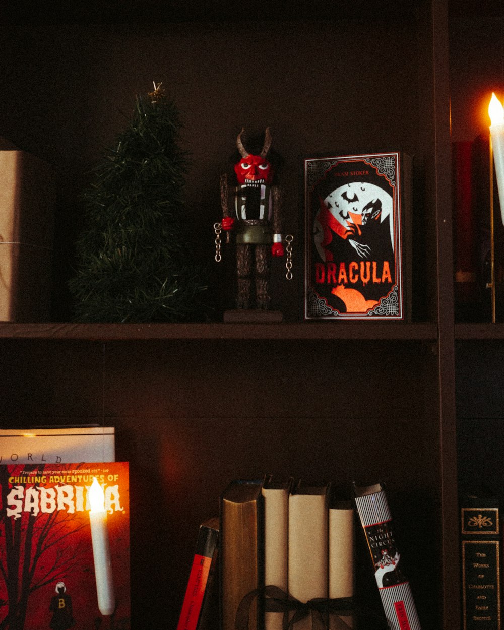 a shelf with books, candles, and other items on it