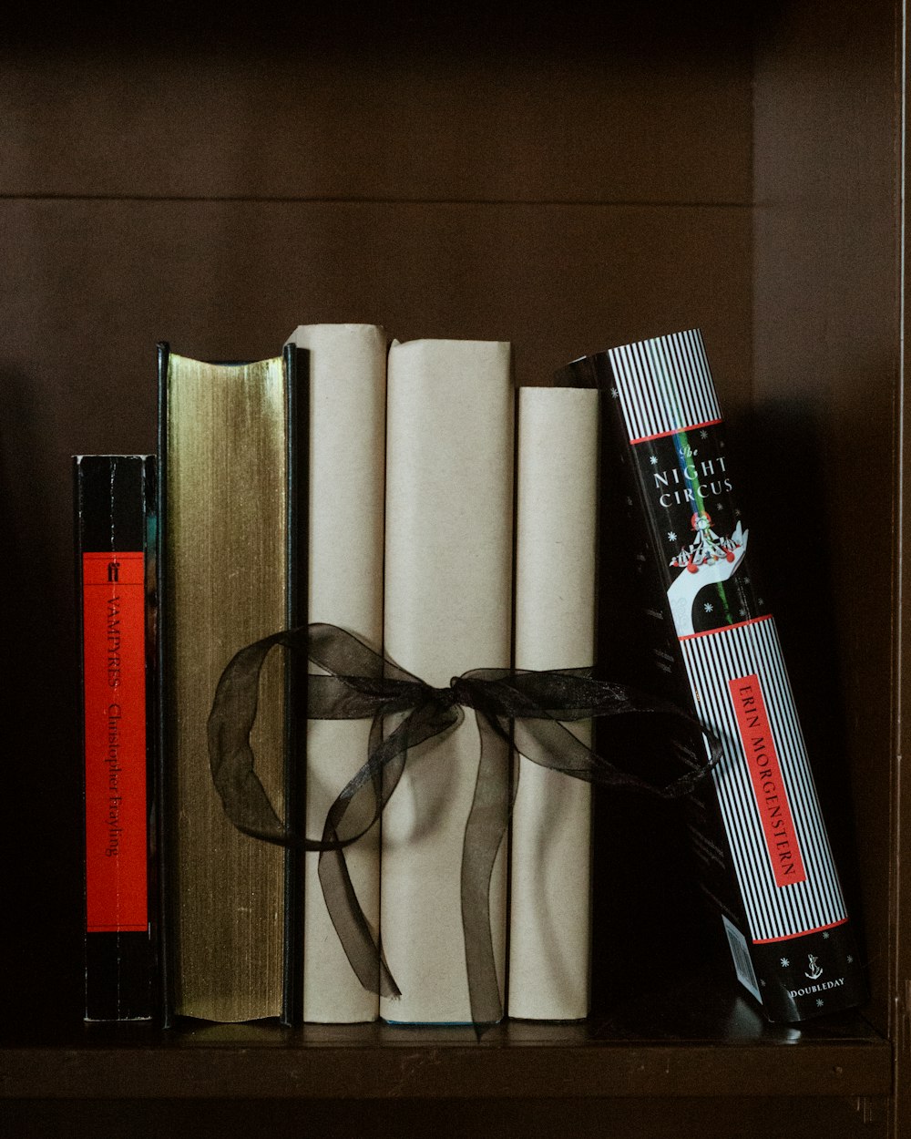 a row of books with a ribbon tied around them