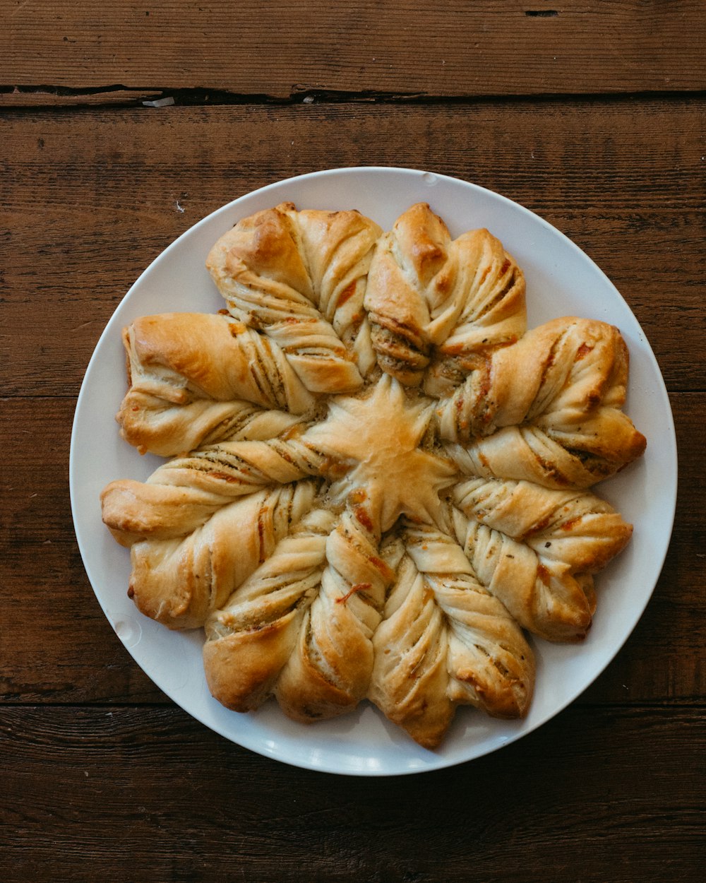 a white plate topped with pastry pieces on top of a wooden table