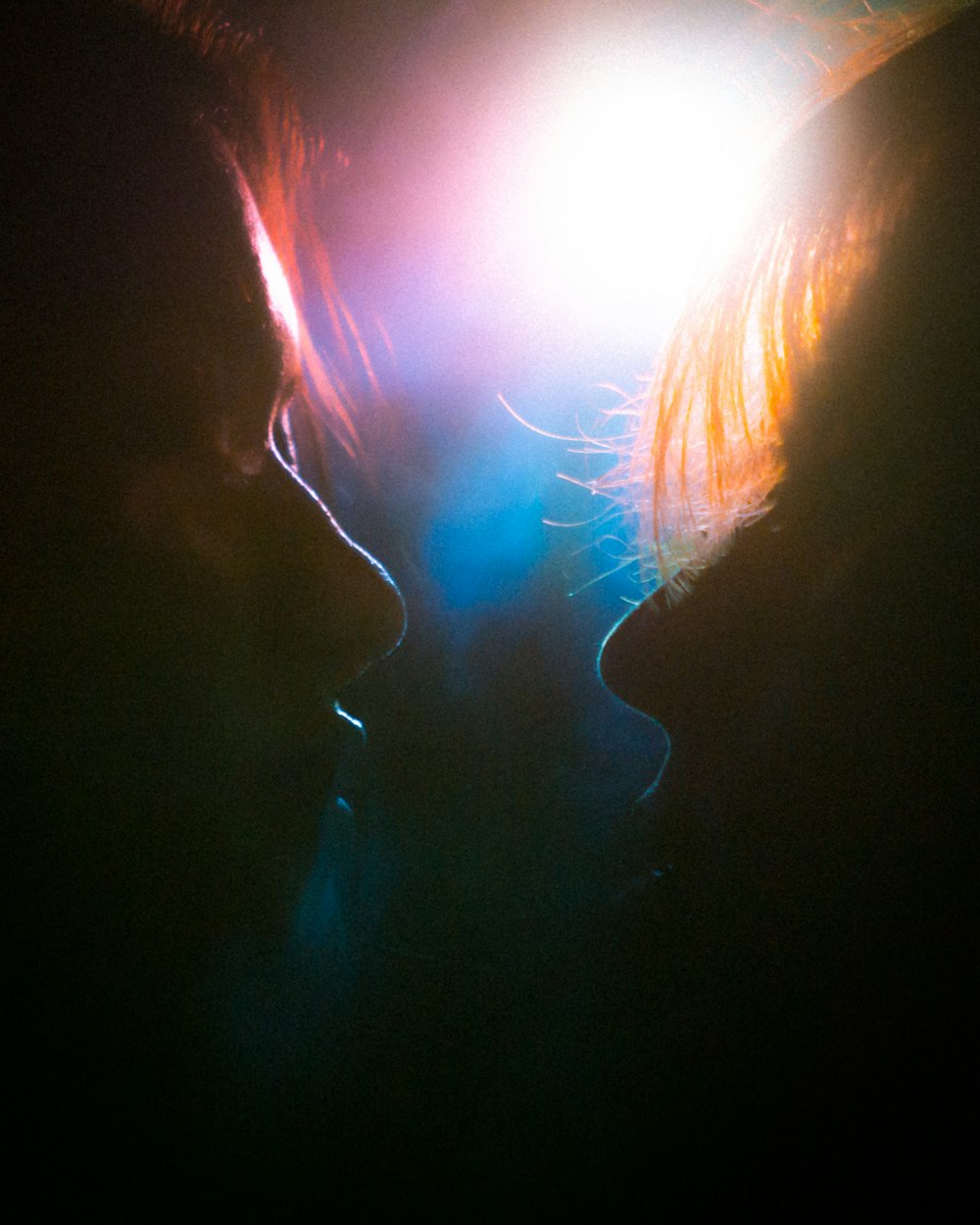 a couple of people that are kissing in the dark