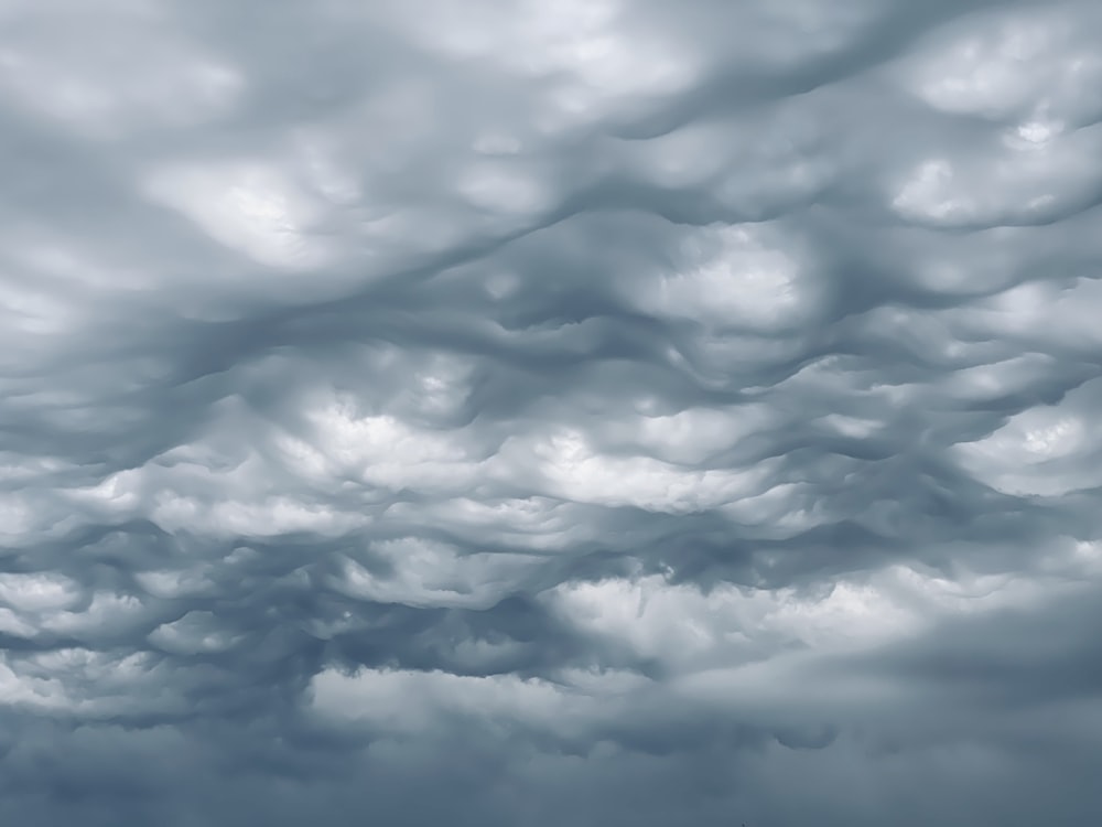 um céu muito nublado com um avião à distância