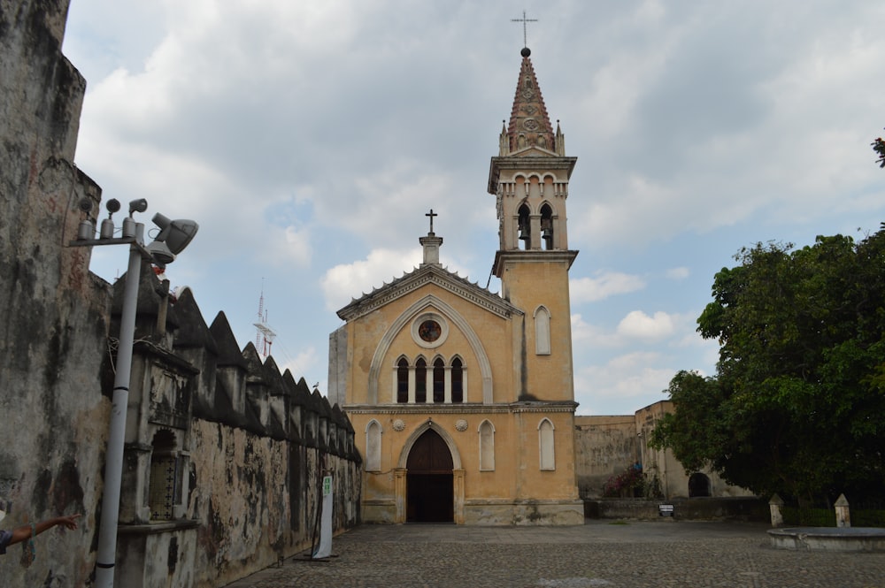 an old church with a steeple on a cloudy day