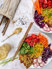 two bowls of salad with strawberries, carrots, radishes, and