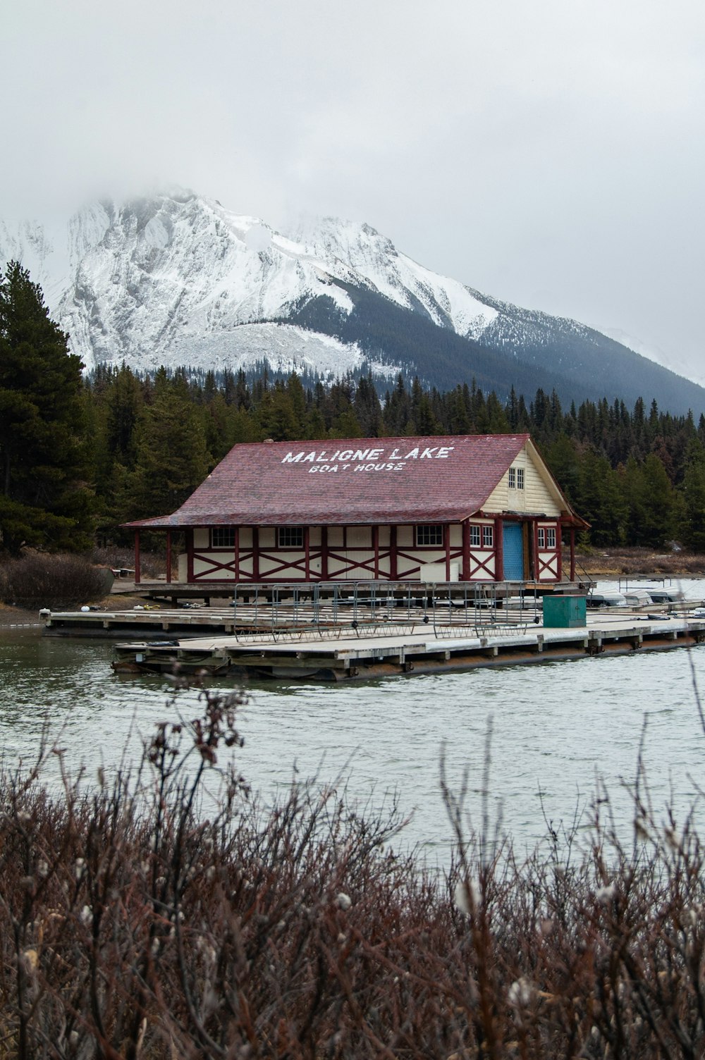 a boat dock in front of a snow covered mountain