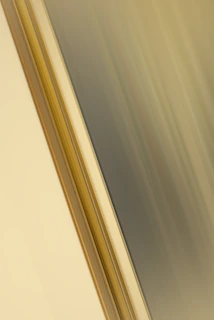 Abstract geometric shapes in muted gold and dark gray overlaying a blurred car dashboard.