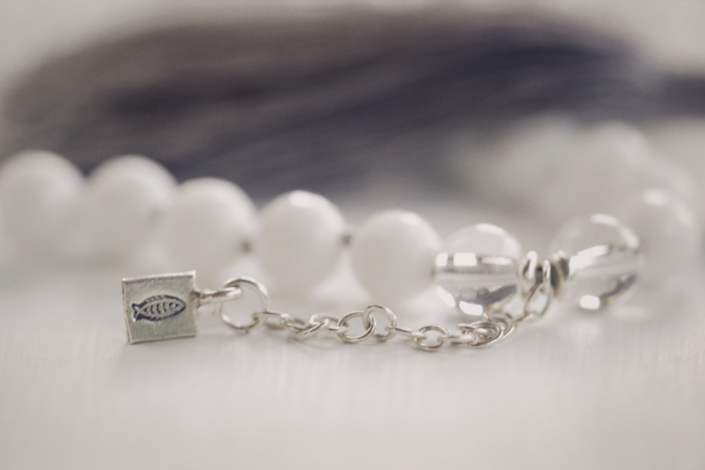 a close up of a white beaded bracelet