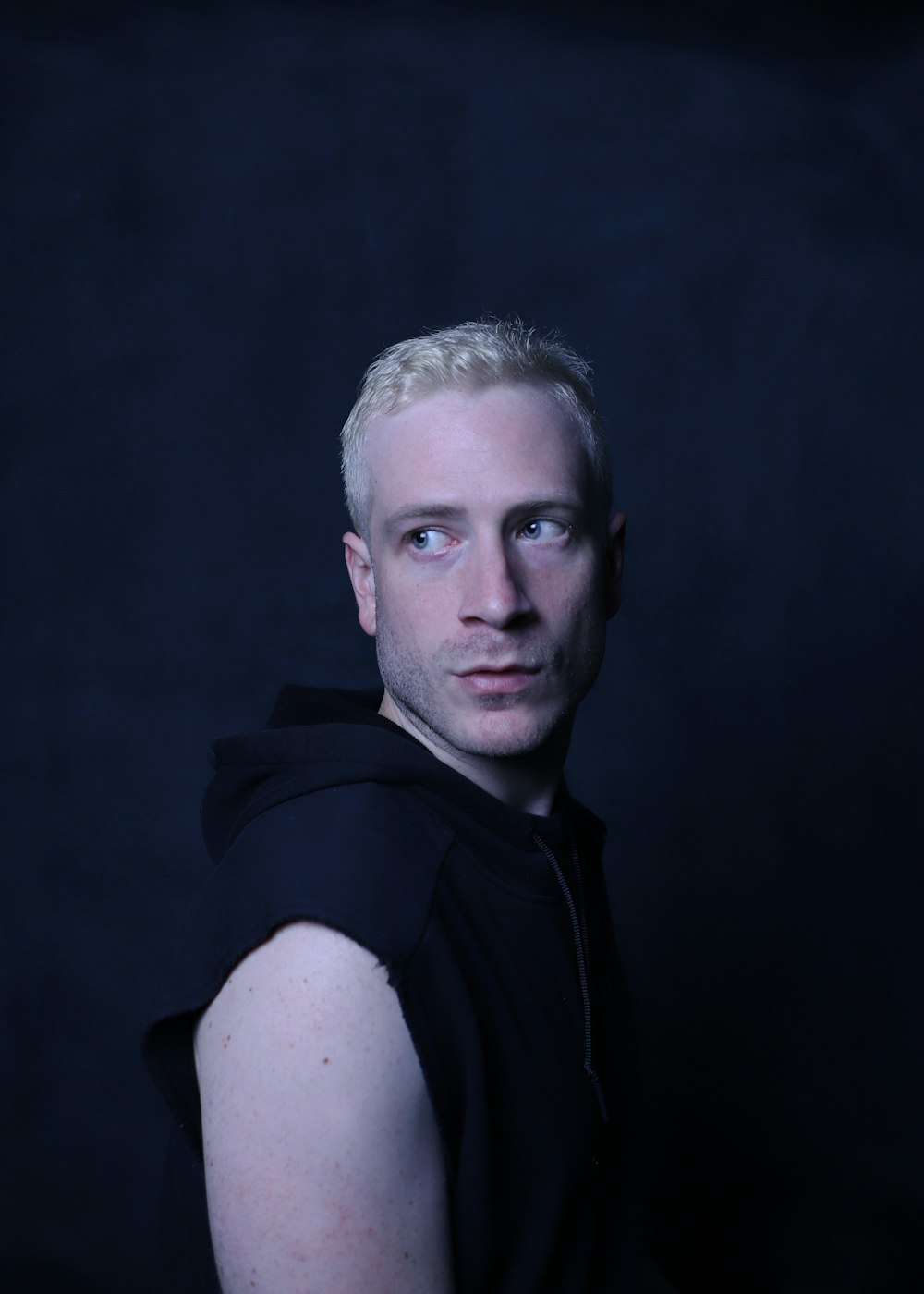 a man with blonde hair wearing a black hoodie
