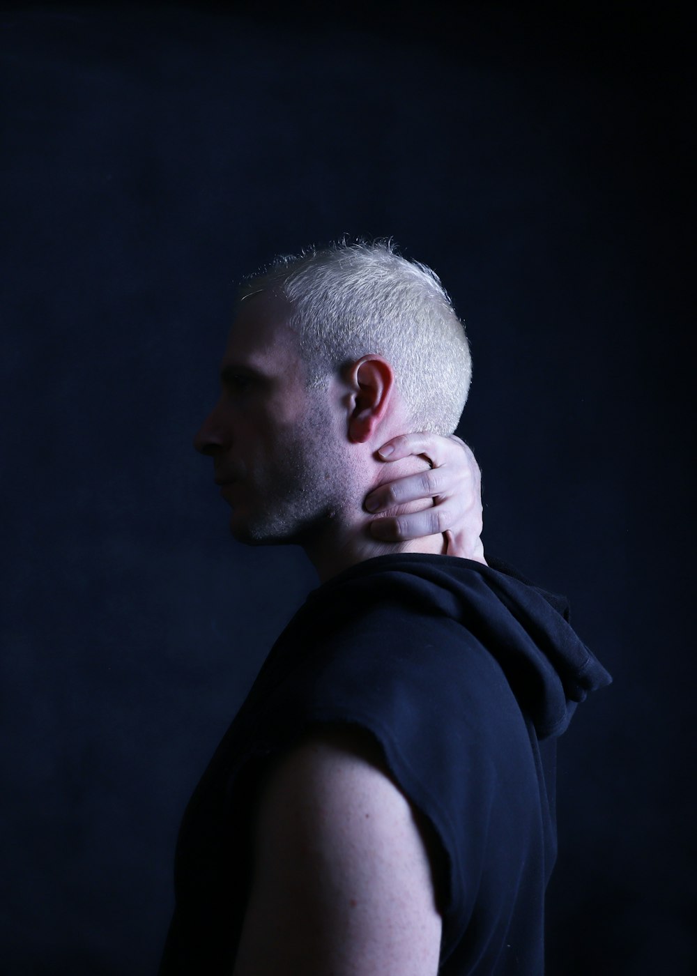a man with a shaved head wearing a black shirt
