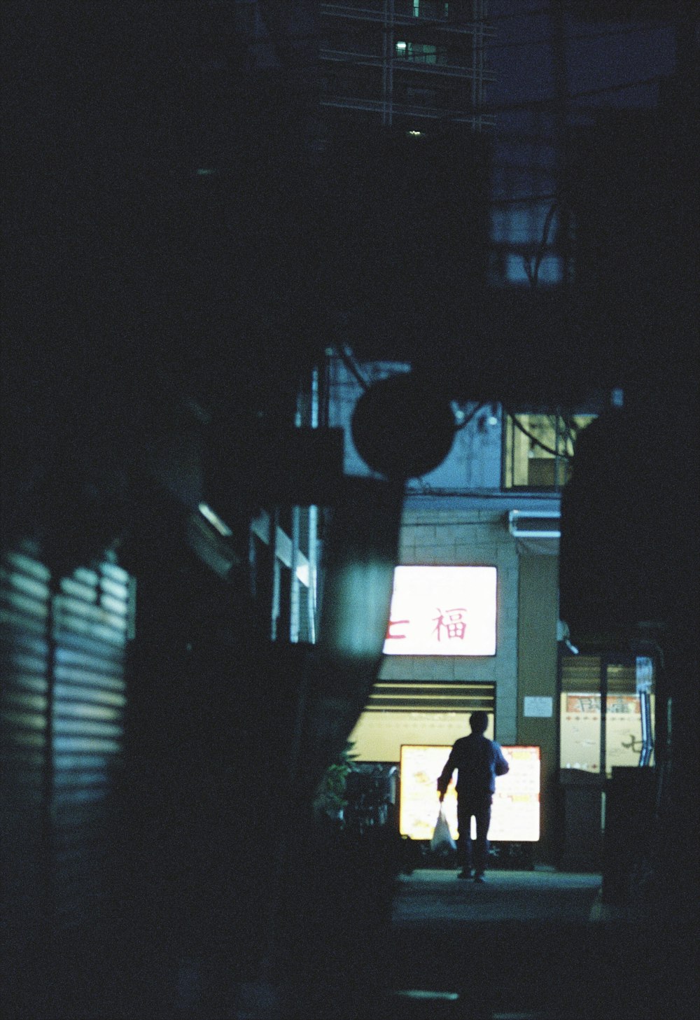 a man walking down a street at night